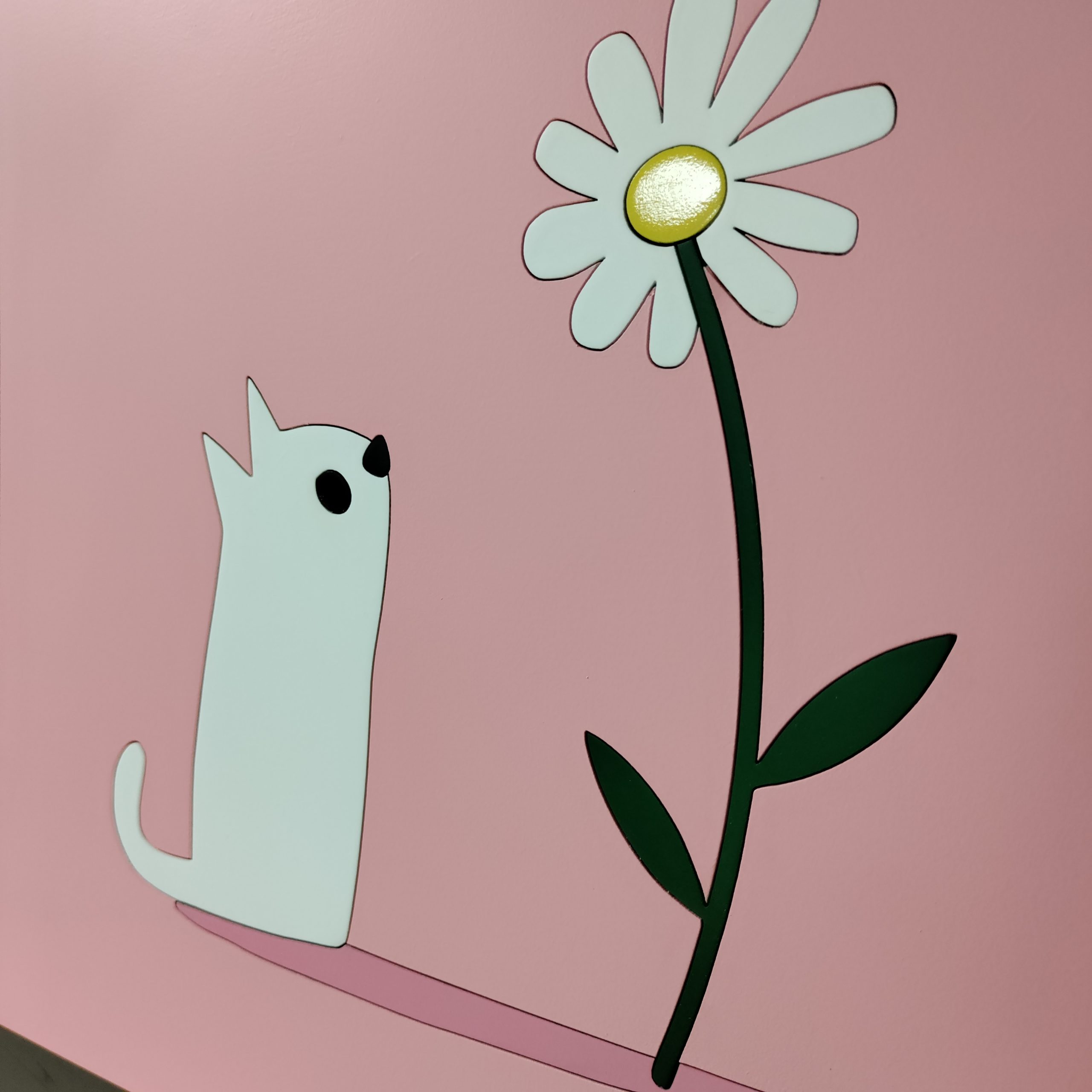 tableau en bois d'un chaton qui regarde une fleur sur fond rose